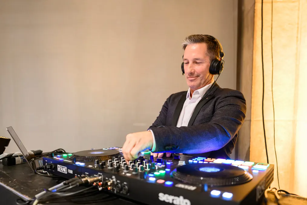 DJ mit Kopfhörern am Pult sorgt für die Musik des Abends