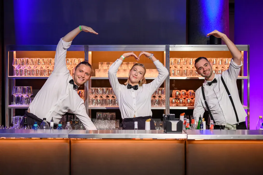 Barteam formt hinter der Bar gemeinsam ein Herz