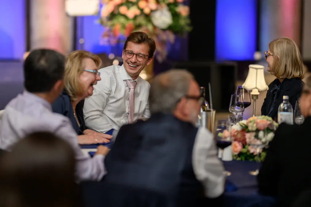 Gäste lachen im Gespräch an einer festlich gedeckten Tafel
